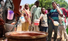 People hold pots as volunteers distribute food in Omdurman, Sudan, September 3, 2023. REUTERS/El Tayeb Siddig