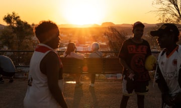 Boys play as people watch the sun setting over Alice Springs.