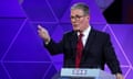 Keir Starmer stands a podium during the debate. He is gesturing with his hand in front of him