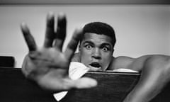 Cassius Clay, as he was known then before changing his name to Muhammad Ali, lies on his hotel bed in London, holding up five fingers in a prediction of how many rounds it will take him to knock out British boxer Henry Cooper.