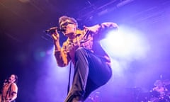 James Smith on stage at UAE Norwich, photographed from below, left knee up, looking dynamic