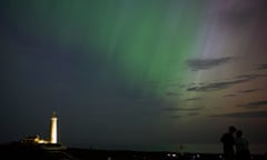 People by St Mary's lighthouse in Whitley Bay look at the aurora borealis