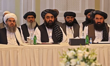 Two rows of bearded men sit at a conference table.