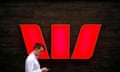 Man walking past Westpac bank logo