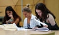 three seated female A-level pupils look at their results