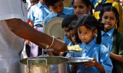 A girl looks at food served to her for free at a government-run school in Bangalore, India
