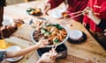 Asian family celebrating Chinese New Year and enjoying scrumptious traditional Chinese poon choi.