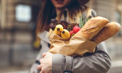 Young woman carrying groceries in a paper bag