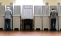 People voting at voting booths in a hall