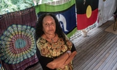 Kali Sailor stands in front of the Aboriginal flag and the Torres Strait flag on the deck of her far north Queensland home