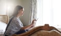 Woman sitting on bed using tablet computer