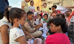 Aid workers care for children affected by the floods in Derna