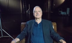 John Cleese sits in an armchair