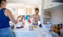 Australian mother of two young children in her family home participating in domestic life activities<br>Posed by models Single Mother with her daughter and son at home playing, working and involved in domestic duties.