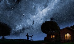 A man gazes at the Milky Way outside his house at night.