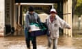 People are seen evacuating a pet dog through flood water In Rochester, Victoria, Friday, October 14, 2022.