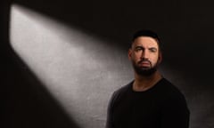 Picture of Marc Conway with beard against dark background with shaft of light running through