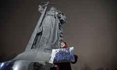 A protester holds a poster that reads: “Enough Putin for me” as she stages a one-woman protest in front of the monument of Prince Vladimir next to the Kremlin in Moscow.