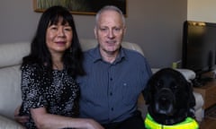 Dr David Squirrell, Christina and their guide dog, Viking, at home in Hallett Cove, South Australia. David - has been fighting the NDIA for 6 years now. He is deafblind and can't find a suitable carer in the Adelaide region to meet his needs. His wife has the qualifications but because they are married the NDIA won't fund her.