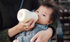 Woman giving a baby a bottle of milk