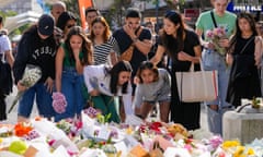 Members of the public add flowers to the expanding mass near the crime scene at Bondi Junction in Sydney, where six people were stabbed to death at Westfield Shopping Centre on Saturday. 