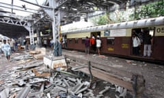 Indian commuters walk past site of explosion at Mahim railway station in Mumbai, July 2006