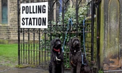 Two dogs sit outside a polling station at St Matthew’s church in Hayfield on December 12, 2019 in High Peak, England. 