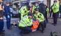 Police removing an Insulate Britain protester from the road in Bishopsgate