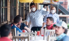 US-HEALTH-VIRUS-BUSINESS-REOPEN<br>A waiter wearing a mask and gloves delivers food to a table to customers seated at an outdoor patio at a Mexican restaurant in Washington, DC, May 29, 2020. - Friday marks the beginning of phase one in the city with restaurants reopening following the stay at home orders from the COVID-19 pandemic, provided they can serve customers outdoors with groups sitting at least 6 feet apart. (Photo by SAUL LOEB / AFP) (Photo by SAUL LOEB/AFP via Getty Images)