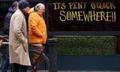 Irish men walk past a sign in the window of Bar Rua in Dublin's city centre