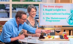 Michael Mosley reaching towards a glass of red wine on a board containing food and drink in a feature on weight loss