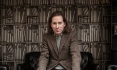 Director Wes Anderson sitting in front of library-inspired wallpaper in London in 2014.