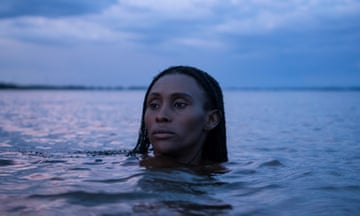 Portrait of a woman in a river, gazing calmly above the water with only her head visible