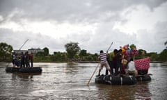 MEXICO-MIGRATION-FEATURE<br>Migrants use a makeshift raft to cross the Suchiate river, natural border between Mexico and Guatemala, in Ciudad Hidalgo, Chiapas state, Mexico on August 31, 2014. Migrants use rafts on their way to the United States. AFP PHOTO/ Yuri CORTEZ (Photo credit should read YURI CORTEZ/AFP/Getty Images)