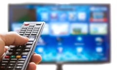 Television remote control changes channels thumb on the blue TV screen<br>D2R4EP Television remote control changes channels thumb on the blue TV screen