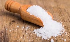 Coarse salt in a wooden scoop.