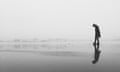 Woman walking along on beach - black and white