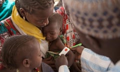 An health official measures the arm circumference of a child at a Unicef clinic near Diwka, Borno State, in February 2017.