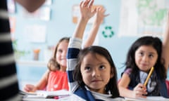School children raising their hands to answer a question