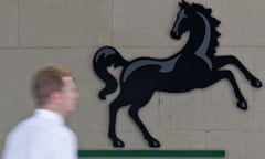 A man passes a Lloyds Banking Group logo
