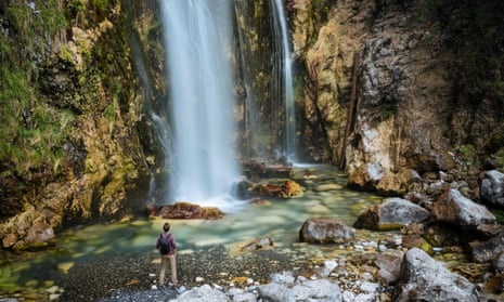 A hiker at a waterfall in Albania’s Accursed Mountains. 