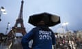 A member of staff uses an umbrella during the Paris Olympics opening ceremony