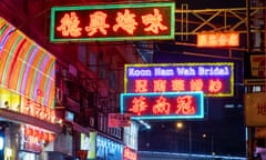 Neon signs hanging over a road in Hong Kong.