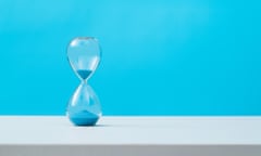 Hourglass with blue sand on the table.