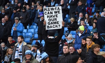 A Manchester City supporter holds an anti-VAR placard.