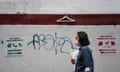 A woman walks past graffiti made by feminist organisations announcing telephone lines and social networks to help women who want an abortion in Caracas in July, 2023