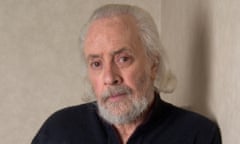 portrait of man wearing black shirt in front of taupe backdrop