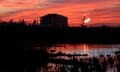 A swamp with a LNG plant in the background flaring off gas.