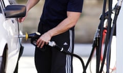 A driver fills up his car at a petrol station 