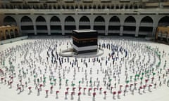 Hundreds of Muslim pilgrims circle the Kaaba, the cubic building at the Grand Mosque, as they observe social distancing.